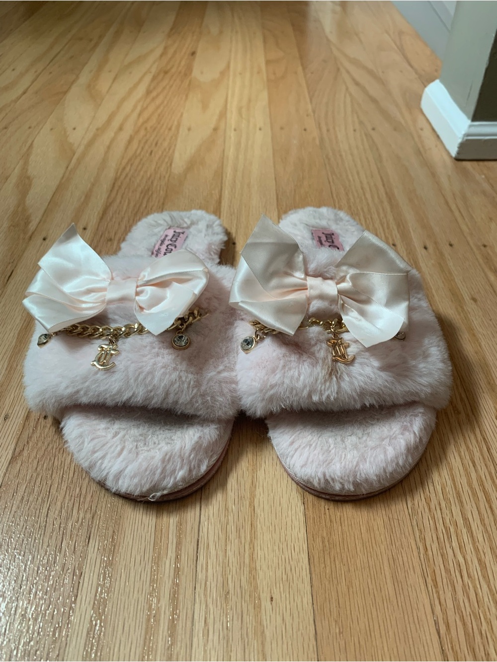 Pink Juicy Couture fuzzy slippers with white bows and gold charms